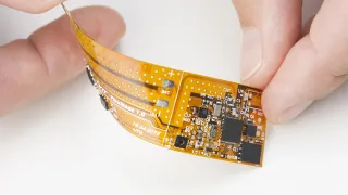 Hand holding flexible printed electronics sheet
